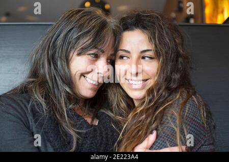 bella e felice figlia con felice madre matura abbracciando e. guardando negli occhi Foto Stock
