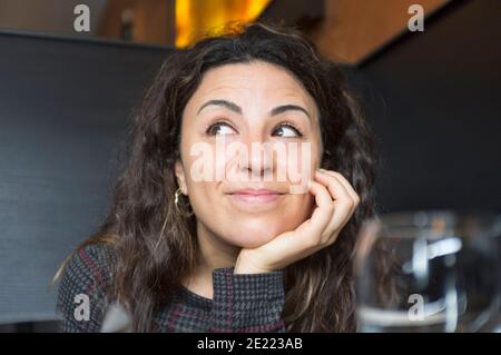 Ritratto di donna sorridente che appoggia il mento sulla mano ristorante Foto Stock