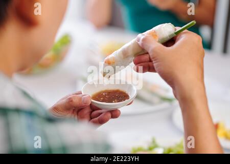 Immagine ravvicinata della cena con gli ospiti che si tuffano in primavera piccola ciotola di salsa Foto Stock