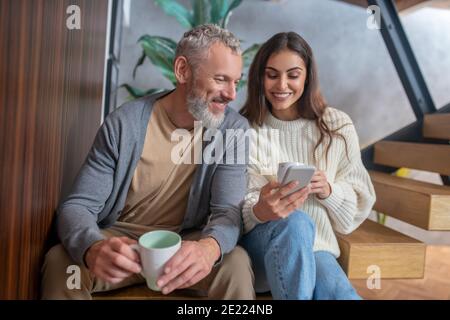 Coppia sposata seduta sulle scale e con caffè Foto Stock