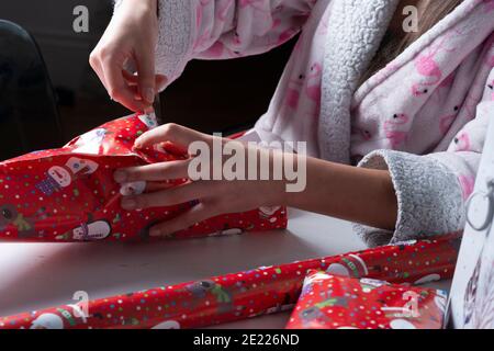 Ragazza avvolge regali di Natale-primo piano Foto Stock