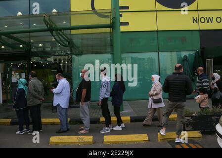 Beirut, Libano. 11 Gennaio 2021. La gente si trova in fila al di fuori di un supermercato locale tra le preoccupazioni di misure rigide che il governo prenderà nel tentativo di frenare la pericolosa diffusione dei casi di coronavirus. Credit: Marwan Naamani/dpa/Alamy Live News Foto Stock