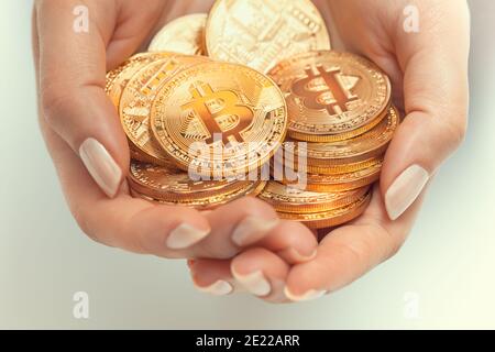 closeup mani donna che tengono gruppo di lucenti bitcoins Foto Stock