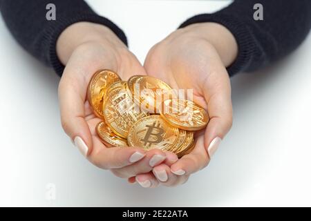 closeup mani donna che tengono gruppo di lucenti bitcoins Foto Stock
