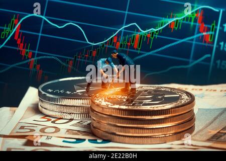 macro minatori che lavorano su pile di bitcoin e di etereo collocate sulle banconote in euro di fronte alla tabella di mercato. virtual criptovalute mining and trad Foto Stock