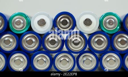 Molte batterie alcaline AA e AAA su sfondo bianco. Concetto di riciclaggio ecologico. I terminali delle batterie monouso sono vicini Foto Stock