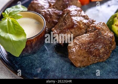 Carne alla griglia in un piatto con verdure stufate primo piano Foto Stock