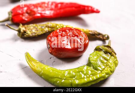 I peperoni e i pomodori del peperoncino sono viziati, sbucciati e deperiti. Cibo brutto. Foto Stock