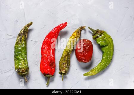 I peperoni e i pomodori del peperoncino sono viziati, sbucciati e deperiti. Cibo brutto. Foto Stock