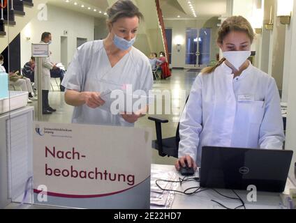 11 gennaio 2021, Sassonia, Lipsia: Presso l'Ospedale Universitario di Lipsia, l'infermiera Bianca (l) e l'assistente studentesca Christina registrano coloro che intendono essere vaccinati in un'ampia sala per il follow-up delle vaccinazioni in una clinica ambulatoriale appositamente allestita contro il virus Corona per personale medico particolarmente a rischio. All'Ospedale Universitario, le aule studentesche sono state convertite in una clinica interna ambulatoriale di vaccinazione. Attualmente, fino a 330 dipendenti medici particolarmente in pericolo vengono vaccinati contro il virus corona. C'è una disponibilità sopra la media tra staf ospedale Foto Stock