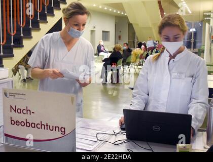 11 gennaio 2021, Sassonia, Lipsia: Presso l'Ospedale Universitario di Lipsia, l'infermiera Bianca (l) e l'assistente studentesca Christina registrano coloro che intendono essere vaccinati in un'ampia sala per il follow-up delle vaccinazioni in una clinica ambulatoriale appositamente allestita contro il virus Corona per personale medico particolarmente a rischio. All'Ospedale Universitario, le aule studentesche sono state convertite in una clinica interna ambulatoriale di vaccinazione. Attualmente, fino a 330 dipendenti medici particolarmente in pericolo vengono vaccinati contro il virus corona. C'è una disponibilità al di sopra della media tra il personale ospedaliero Foto Stock