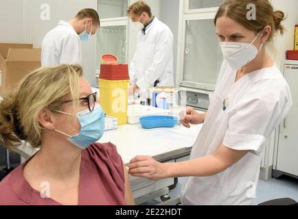 11 gennaio 2021, Sassonia, Lipsia: Presso l'Ospedale Universitario di Lipsia, il medico senior Dr. Corinna Gebauer vaccina MTA Annette in una clinica di vaccinazione appositamente allestita contro il virus Corona per personale medico particolarmente a rischio. All'Ospedale Universitario, le aule degli studenti sono state convertite in una clinica interna ambulatoriale di vaccinazione. Attualmente, fino a 330 dipendenti medici particolarmente in pericolo vengono vaccinati contro il coronavirus. C'è una disponibilità superiore alla media tra il personale ospedaliero ad essere vaccinato. Attualmente vi sono più richieste di appuntamenti per le vaccinazioni Foto Stock