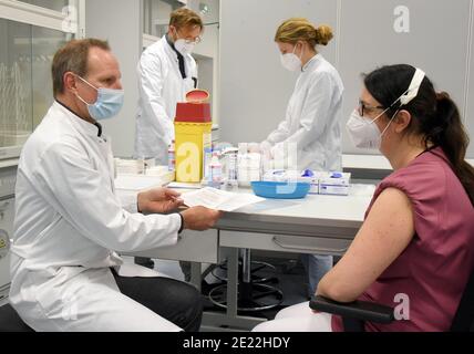 11 gennaio 2021, Sassonia, Lipsia: Presso l'ospedale universitario di Lipsia, il farmacologo e tossicologo il Prof. Michael Schaefer è seduto di fronte all'infermiera Bianca in una clinica di vaccinazione appositamente allestita contro il virus Corona per personale medico particolarmente vulnerabile. All'ospedale universitario, le aule studentesche sono state convertite in una clinica interna ambulatoriale di vaccinazione. Attualmente, fino a 330 dipendenti medici particolarmente in pericolo vengono vaccinati contro il coronavirus. C'è una disponibilità superiore alla media tra il personale ospedaliero ad essere vaccinato. Attualmente sono presenti altre richieste per Foto Stock