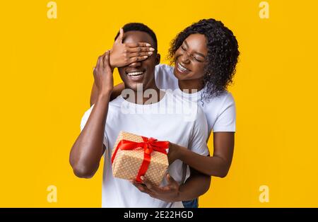 Felice signora nera che dà il regalo al suo ragazzo Foto Stock