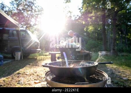 uomo che imposta la cena al campeggio cibo su stufa Foto Stock