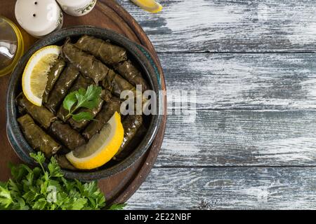 Dolma - foglie di vino greco farcite (dolmades) su sfondo di legno blu Foto Stock