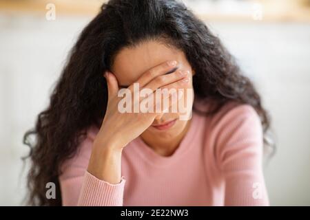 Concetto di depressione. Ritratto closeup di giovane donna stressata che tocca la testa nella disperazione Foto Stock