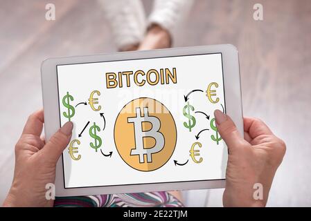 Il concetto di Bitcoin mostrato su un tablet tenuto da una donna Foto Stock