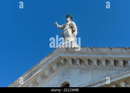 San Giorgio maggiore - Vista a basso angolo di una statua religiosa in cima alla façade della cinquecentesca Basilica di San Giorgio maggiore. Venezia, Italia. Foto Stock