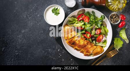 Delizioso merluzzo impanato con insalata in un piatto Foto Stock