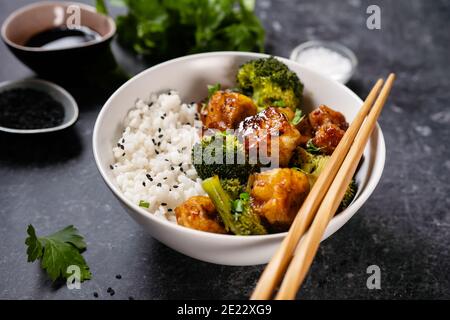 Ciotola vegana asiatica con riso, broccoli e tofu fritto Foto Stock