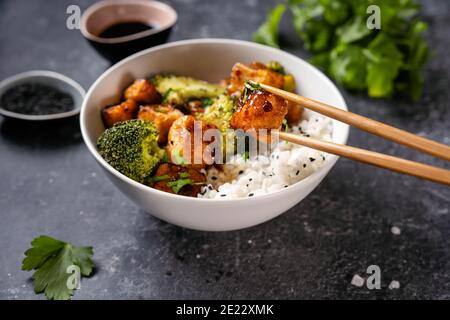 Tofu vegano fritto con broccoli e riso Foto Stock