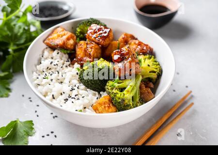 Ciotola vegana asiatica con riso, broccoli e tofu fritto Foto Stock