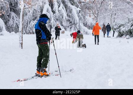 L'uomo sciando in un parco nel centro di Madrid durante una nevicata pesante. Filomena nevicata pesante. Madrid, Spagna Foto Stock