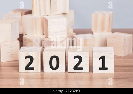 Blocchi di legno con i numeri 2021 l'inizio del nuovo anno sul tavolo. Buon anno e concetto di vacanza. Foto Stock