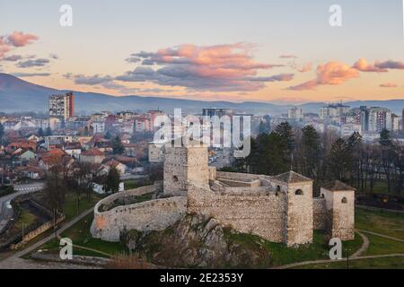 Bellissimi colori tenui delle nuvole su un cielo al tramonto sopra l'antica fortezza di fronte a un paesaggio panoramico, mistico e sognante di Pirot, Serbia Foto Stock