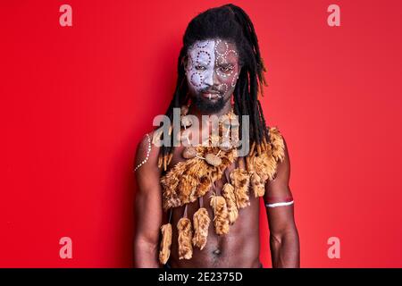 sciamano nero con make-up etnico nazionale sul corpo, viso. giovane maschio con dreadlock è fiducioso in se stesso Foto Stock