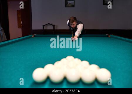 uomo che tiene il braccio sul tavolo da biliardo, che gioca a biliardo o che si prepara a sparare palline da biliardo. gioco di sport biliardo snooker Foto Stock