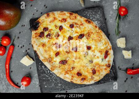 Caldi quattro formaggi deliziosa pizza rustica americana con spessa crosta su tavola nera. Foto Stock