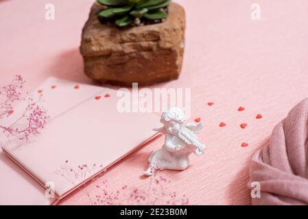 Preparazione per San Valentino: Un taccuino per le congratulazioni o note dolci, caramelle al cioccolato, cuori feltrati e una tazza di tè, copia spazio vista dall'alto Foto Stock