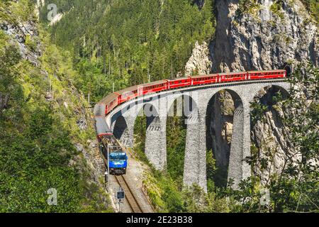 Landwasser Viaduct a Filisur, Svizzera. E' un famoso punto di riferimento della Svizzera. Treno espresso rosso sull'alto ponte in montagna. Vista panoramica su Amazing Foto Stock