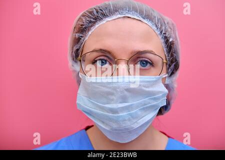 Donna medico in maschera medica su sfondo rosso, copia spazio per il testo. Epidemia di coronavirus, concetto di quarantena del virus influenzale Foto Stock