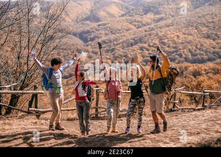 Felici escursionisti in piedi sul glade e di allegria. In foresta di sfondo. Stagione autunnale, concetto di avventura. Foto Stock