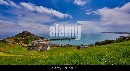 Immagine del castello di Gorey con il porto, il mare calmo della baia di Grouville, il cielo blu e le nuvole. Jersey, Isole del canale. Foto Stock