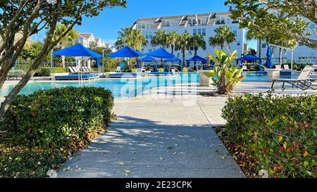 Orlando, FL USA - 4 Gennaio 2021: Un complesso di servizi nelle vicinanze che appare come un resort con palme, getti d'acqua e cabanas. Foto Stock