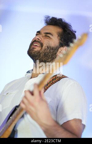 Musicista ispanico emozionale maschile cantando appassionatamente e giocando su elettrico chitarra in studio Foto Stock