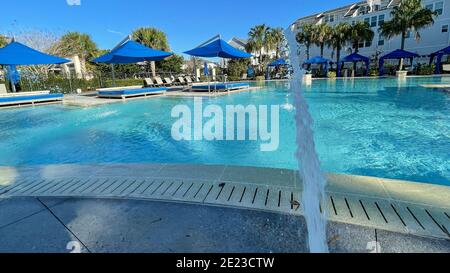 Orlando, FL USA - 4 Gennaio 2021: Un complesso di servizi nelle vicinanze che appare come un resort con palme, getti d'acqua e cabanas. Foto Stock