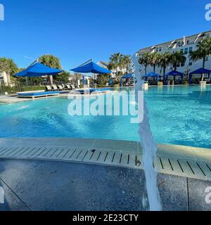 Orlando, FL USA - 4 Gennaio 2021: Un complesso di servizi nelle vicinanze che appare come un resort con palme, getti d'acqua e cabanas. Foto Stock