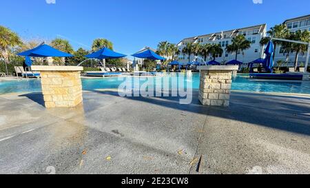 Orlando, FL USA - 4 Gennaio 2021: Un complesso di servizi nelle vicinanze che appare come un resort con palme, getti d'acqua e cabanas. Foto Stock