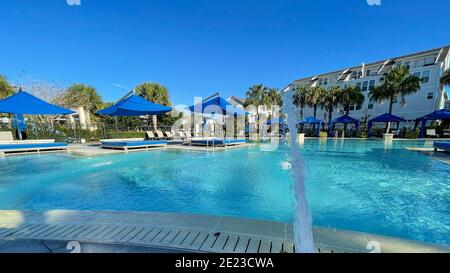 Orlando, FL USA - 4 Gennaio 2021: Un complesso di servizi nelle vicinanze che appare come un resort con palme, getti d'acqua e cabanas. Foto Stock