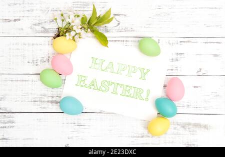 Decorazione delle uova di Pasqua con fiori di primavera su sfondo di legno Foto Stock