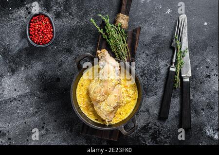 Unches di coniglio arrosto in padella con verdure stufate. Sfondo nero. Vista dall'alto Foto Stock