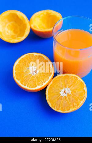 Succo d'arancia appena spremuto su sfondo blu Foto Stock
