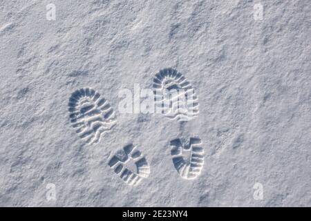 Stampa da scarpe nella neve. Libera le impronte sulla neve bianca appena caduta. Giorno invernale limpido e soleggiato. Spazio di copia. Foto Stock