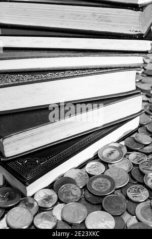 Mucchio di libri classici circondati da monete [Bianco e nero versione] Foto Stock