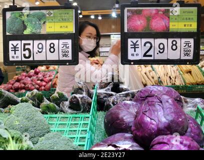 Pechino, la provincia cinese di Jiangsu. 11 Gennaio 2021. Un cliente acquista le verdure in un supermercato a Nanjing, nella provincia di Jiangsu, nella Cina orientale, 11 gennaio 2021. L'indice dei prezzi al consumo (CPI), un indicatore principale dell'inflazione, è aumentato del 2.5% su base annua nel 2020, rimanendo all'interno dell'obiettivo annuale del governo di circa il 3.5%. Credit: Sun Zhongnan/Xinhua/Alamy Live News Foto Stock